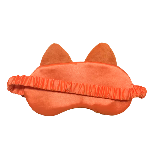 An orange cat-themed sleep mask with plush ears and a ruffled elastic band, shown against a plain white background.