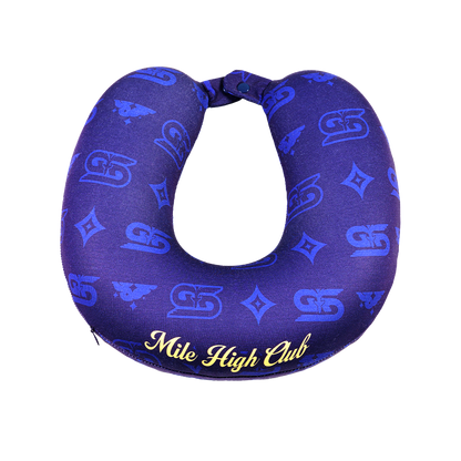 Close-up of a dark blue neck pillow with yellow "Mile High Club" text and subtle patterned design.