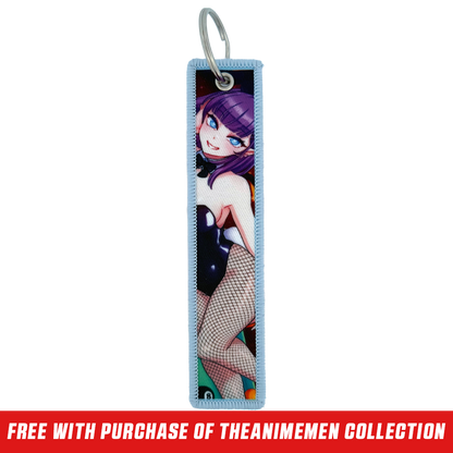 Keychain tag with anime-style purple-haired character, blue eye, and pink heart playing card design on light blue border.